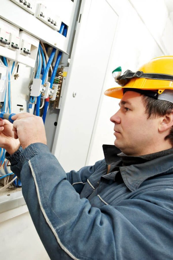 Man Working on a Switchboard With Screw Driver Image 2